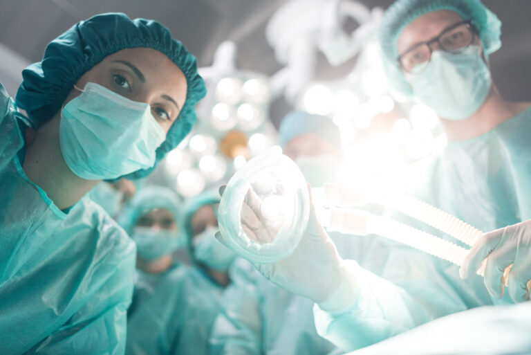Medical team performing surgical operation in modern operating room at hospital